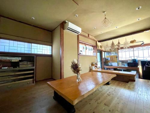 ein Wohnzimmer mit einem Holztisch und einem Sofa in der Unterkunft 古民家の宿 鎌倉楽庵 in Kamakura