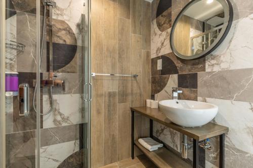 La salle de bains est pourvue d'un lavabo et d'une douche. dans l'établissement Studio 42 with kitchenette at the new Olo living, à Paceville