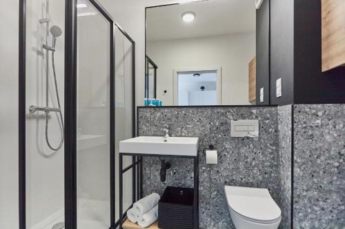 a bathroom with a sink and a toilet at Pelikan Apartments - Parking w cenie - Parkplatz inklusive in Świnoujście