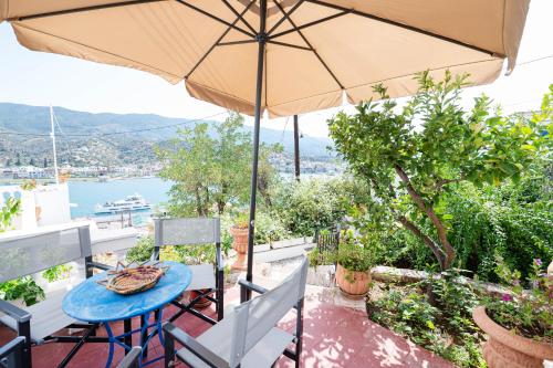 a patio with an umbrella and a table and chairs at Traditional House under the Clock Tower with Sweet View in Poros