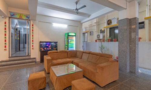 Treebo Trend Pranav Park في فيلوري: غرفة معيشة مع أريكة وتلفزيون
