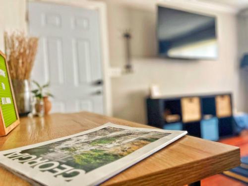 a magazine sitting on top of a wooden table at Quiet & Quaint apartment, 5 mins to airport and 15 mins to downtown in Atlanta