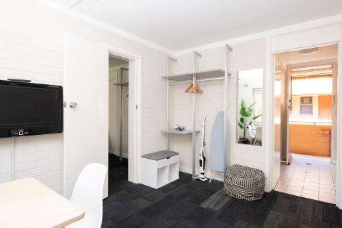 sala de estar con paredes blancas y TV de pantalla plana en Central location 2 bdrm free parking and WiFi, en Perth