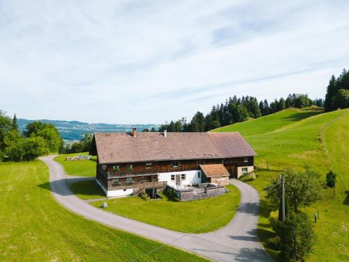 an old barn on a hill with a winding road at Haus Berchtold am Hüttersberg in Doren