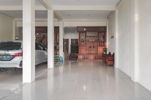 a hallway with a car parked in a house at RedDoorz Syariah @ Penginapan Citra Alam 2 in Sungaitutung