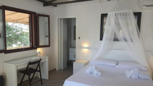 1 Schlafzimmer mit 2 Betten, einem Schreibtisch und einem Fenster in der Unterkunft Sotto la Torre e sopra il Porticciolo in Ustica