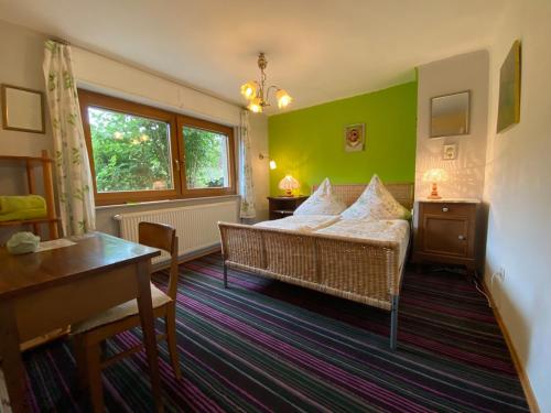 1 dormitorio con cama, mesa y ventana en Kräuterhaus - herbgarden, en Kleinich