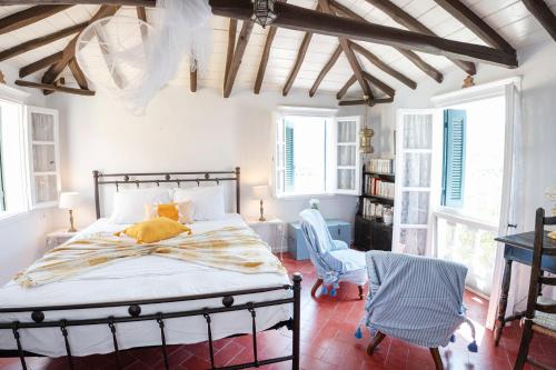 ein Schlafzimmer mit einem Bett in einem Zimmer mit Fenstern in der Unterkunft Traditional House under the Clock Tower with Sweet View in Poros