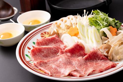 a plate of food with meat and vegetables on a table at Urari Takeo Garden Terrace Spa Resorts in Takeo