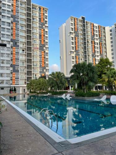 a swimming pool in front of some tall buildings at Timurbay Seafront Residence & Suites in Kuantan
