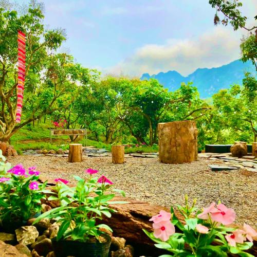 a garden with pink flowers and a picnic table at Mường Sang Retreat in Mộc Châu