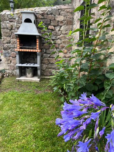 una casa de pájaros en un jardín con flores púrpuras en La Casita de Cuestallano, en Renedo