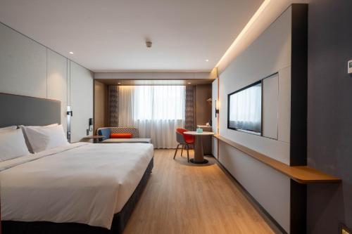 a hotel room with a bed and a television at Holiday Inn Express Shanghai Pujiang Lianhang Road by IHG in Shanghai