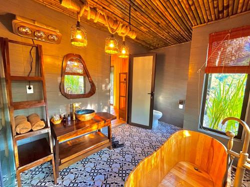 a bathroom with a tub and a table and a sink at Mường Sang Retreat in Mộc Châu