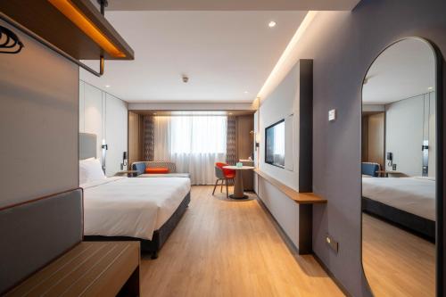 a hotel room with two beds and a desk at Holiday Inn Express Shanghai Pujiang Lianhang Road, an IHG Hotel in Shanghai