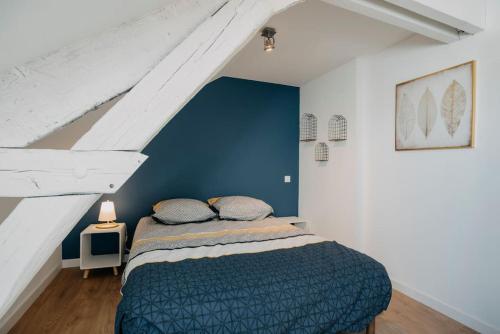 una camera con letto e parete blu di Coeur de ville #H3 - WIFI et NETFLIX - Lave linge - Logement partagé - Chambre privée a Cholet