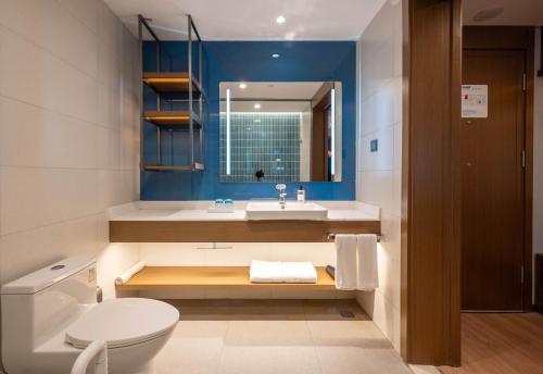 a bathroom with a toilet and a sink and a mirror at Holiday Inn Express Shanghai Pujiang Lianhang Road, an IHG Hotel in Shanghai