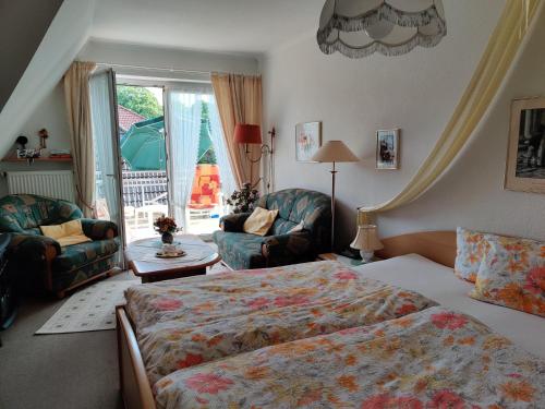 pokój hotelowy z łóżkiem, krzesłami i oknem w obiekcie Landhaus Heide w mieście Schneverdingen