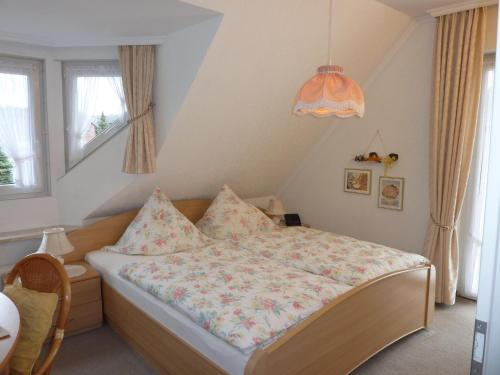 a bedroom with a bed and a chandelier at Landhaus Heide in Schneverdingen