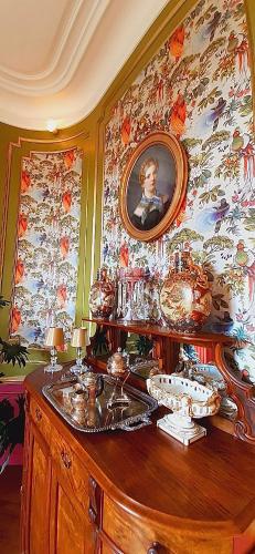 een kamer met een tafel met een foto aan de muur bij Le Château du Breuil in Mazières-de-Touraine