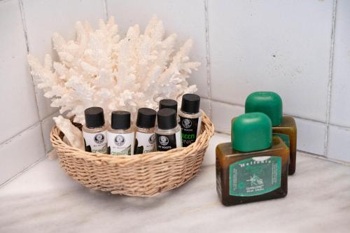 a basket of bottles of essential oils on a bathroom counter at Traditional House under the Clock Tower with Sweet View in Poros