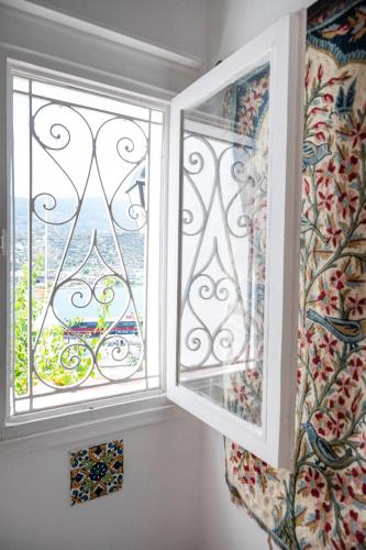 a window with a view of a balcony at Traditional House under the Clock Tower with Sweet View in Poros