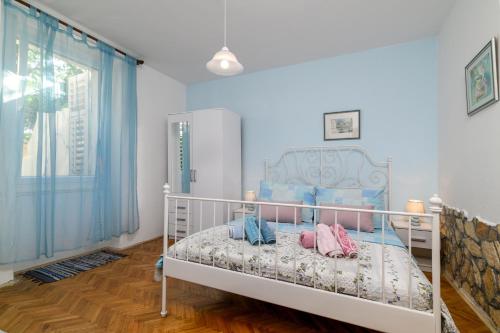 ein Schlafzimmer mit einem weißen Bett mit Kissen darauf in der Unterkunft Apartments with a parking space Pula - 7649 in Pula