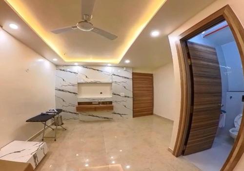 a living room with a ceiling fan and a mirror at Hotel Prago by Green Deer Varanasi in Varanasi