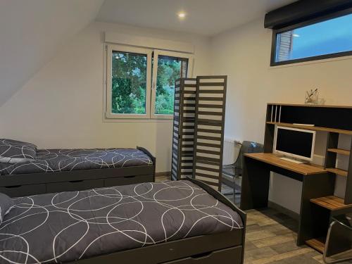 une chambre avec deux lits, un bureau et une télévision dans l'établissement Paisible Duplexe sur Villeneuve d ascq, à Annappes