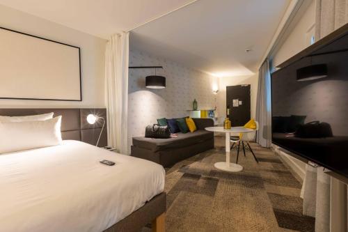 um quarto de hotel com uma cama e um sofá em Novotel Suites Paris Expo Porte de Versailles em Paris