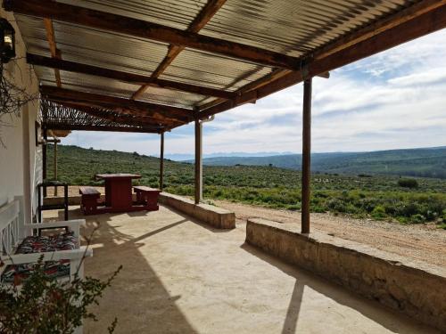 a wooden pavilion with a view of a field at Klein Doorn Farm Stay in Oudtshoorn