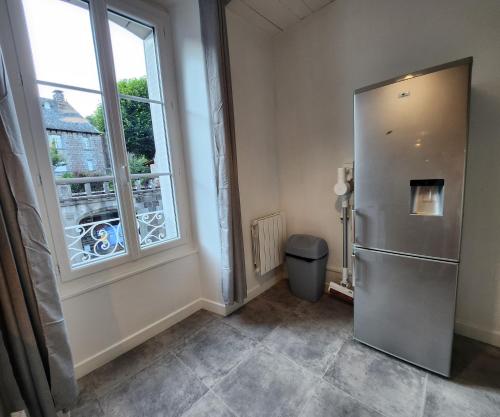 a room with a refrigerator and a window at Chaleureux appartement refait à neuf in Vic-sur-Cère