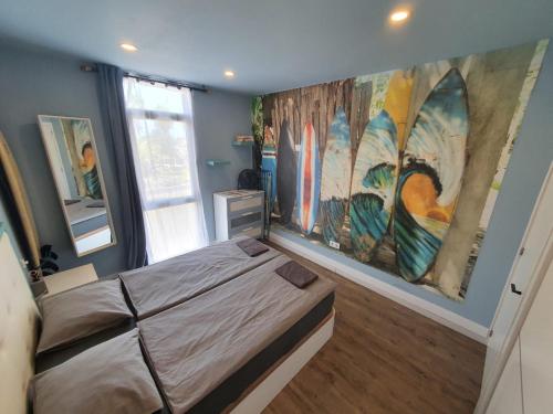 a bedroom with a bed and a large painting on the wall at Surf Station Tenerife Holiday Apartment Las Americas in Playa de las Americas