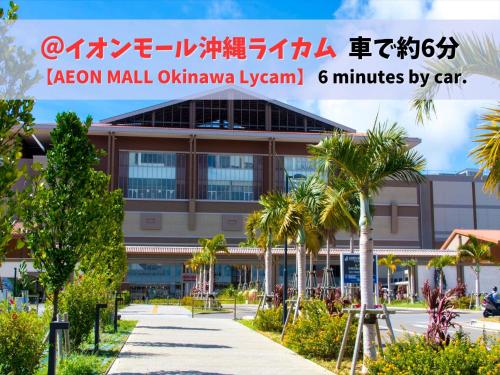 a large building with palm trees in front of it at HOTEL PACIFIC VIEW Rental car included & pet-friendly in Okinawa City