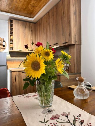 a vase filled with yellow flowers sitting on a table at WoodStar/ტყის ვარსკვლავი in Ambrolauri