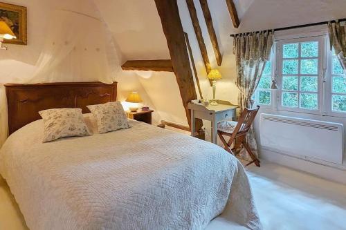 a bedroom with a bed and a desk and a window at Villa Rospico - Plage de sable à 250m in Névez