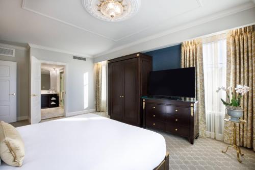 a bedroom with a bed and a flat screen tv at Hotel Carmichael, Autograph Collection in Carmel