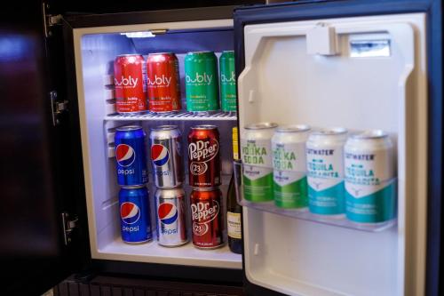 an open refrigerator filled with cans of soda at Hotel Carmichael, Autograph Collection in Carmel