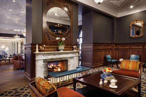 a living room with a fireplace and a table at Hotel Carmichael, Autograph Collection in Carmel