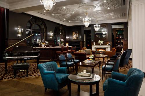 a hotel lobby with a piano and chairs and tables at Hotel Carmichael, Autograph Collection in Carmel