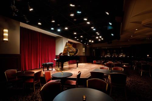 a room with a grand piano and tables and chairs at Hotel Carmichael, Autograph Collection in Carmel