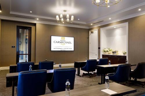 a conference room with tables and chairs and a screen at Hotel Carmichael, Autograph Collection in Carmel