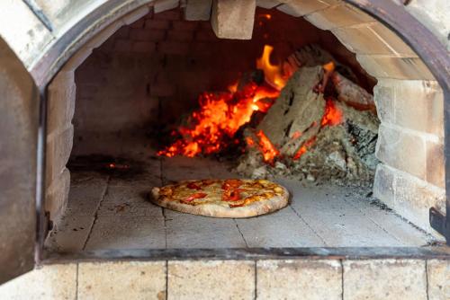 a pizza is cooking in a brick oven at Helena Park - Ultra All Inclusive in Sunny Beach