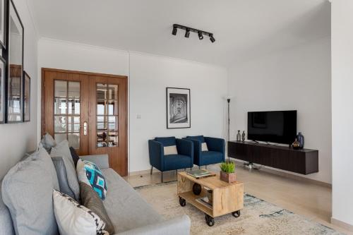 - un salon avec un canapé et une télévision dans l'établissement JOIVY Sunny apartment in Marvila, à Lisbonne