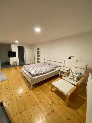 a bedroom with a bed and a couch and wooden floors at Pod lípou in Liberec