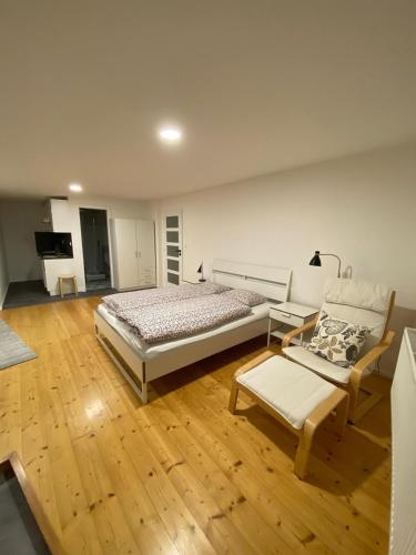 ein Schlafzimmer mit einem Bett und einem Sofa sowie Holzböden in der Unterkunft Pod lípou in Liberec