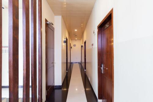 a corridor of a building with wooden doors at RedDoorz near Halim Perdanakusuma 3 in Jakarta
