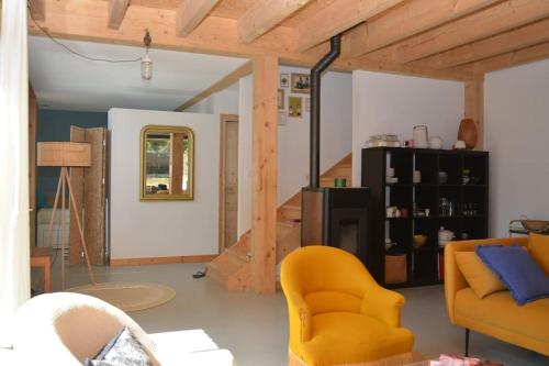 un salon avec une chaise jaune et un canapé dans l'établissement Le charme du bois - 8 à 10 personnes- Maison entière, à La Turballe