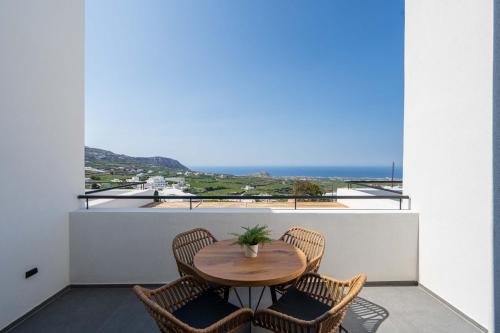 a table and chairs on a balcony with a view of the ocean at La Torretta Suites & Spa in Pirgos