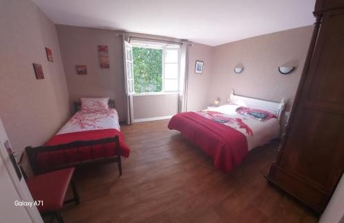 ein kleines Schlafzimmer mit zwei Betten und einem Fenster in der Unterkunft Vacances à la campagne in Noirétable